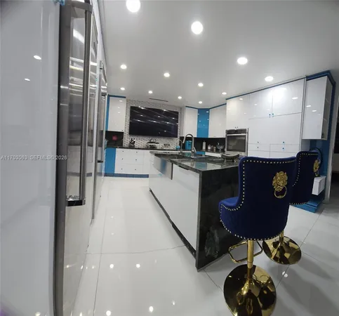 a kitchen with stainless steel appliances kitchen island granite countertop a sink and cabinets