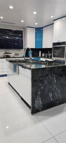 a kitchen with stainless steel appliances kitchen island granite countertop a stove and a microwave