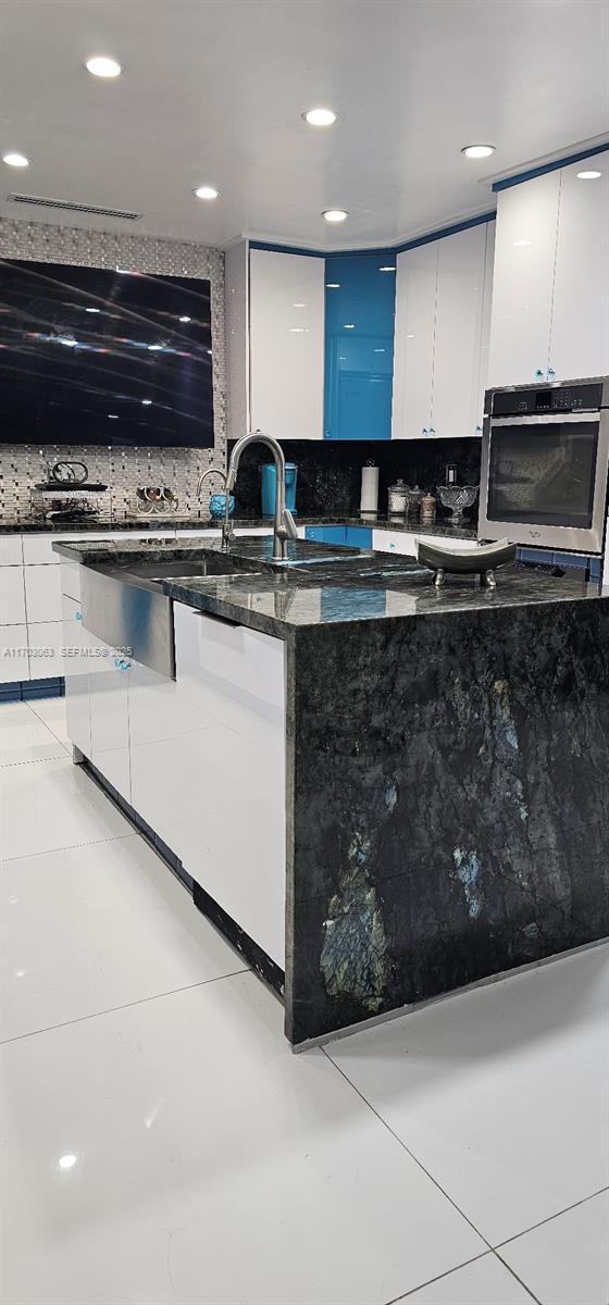 15700 Southwest 202nd Avenue Miami, FL 33187 - Photo 4 of 16 a kitchen with stainless steel appliances kitchen island granite countertop a stove and a microwave