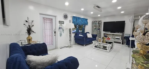a living room with furniture a window and a flat screen tv