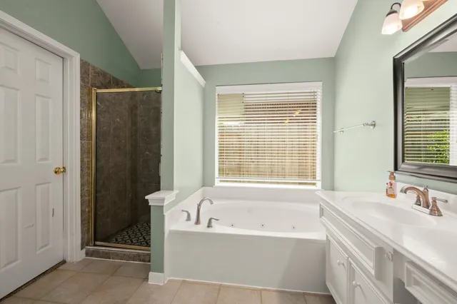 a bathroom with a tub sink and mirror