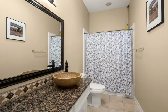 a bathroom with a granite countertop toilet and a shower