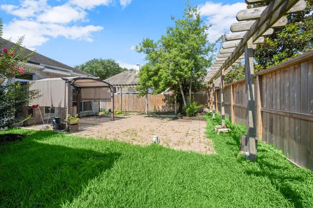 a view of a house with backyard and sitting area
