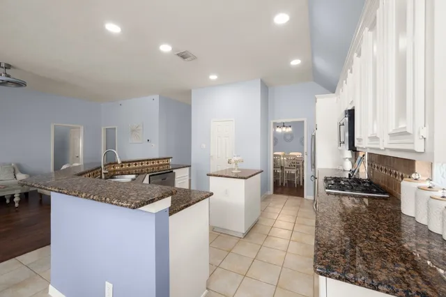 a kitchen with stainless steel appliances granite countertop a sink stove and cabinets