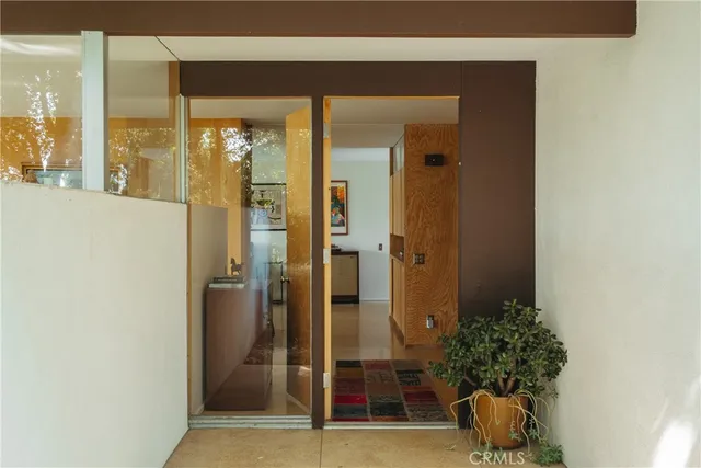 a room with a door and a potted plant