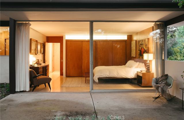 a bedroom with a bed and large windows