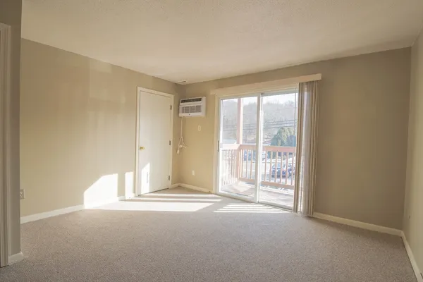 a view of an empty room with furniture and a kitchen