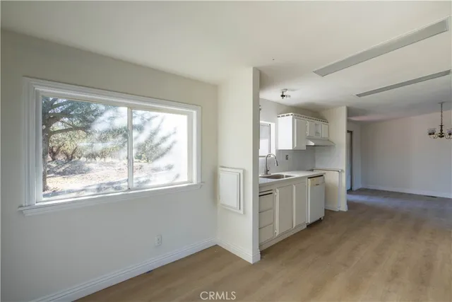 a large kitchen with kitchen island wooden floor wooden cabinets and stainless steel appliances