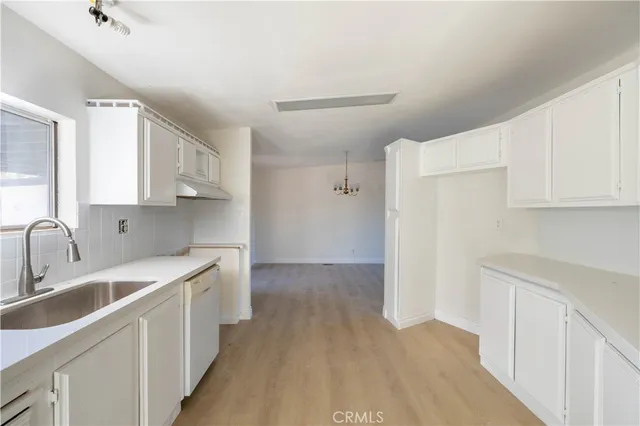 a kitchen with a sink cabinets stainless steel appliances and a window