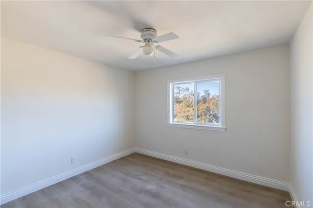 an empty room with a window and a fan