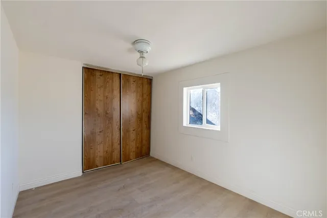 an empty room with windows and closet