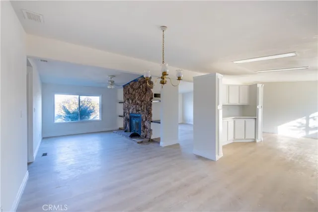 a view of empty room with wooden floor and window