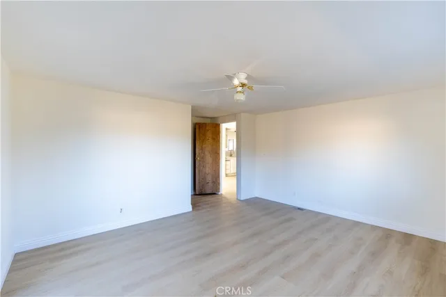 a view of an empty room with a chandelier fan