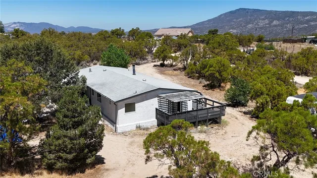 a view of a backyard with couches and wooden fence