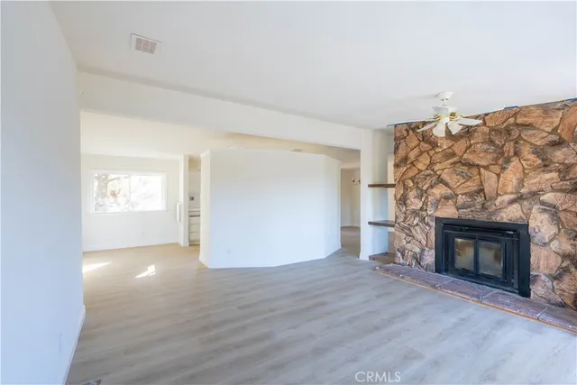 a view of empty room with wooden floor and fireplace