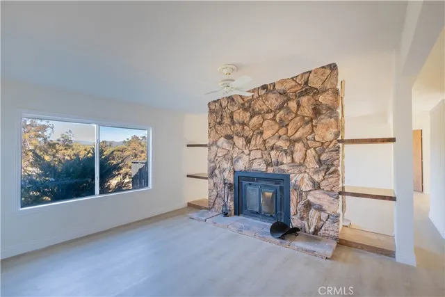 a view of empty room with fireplace and window