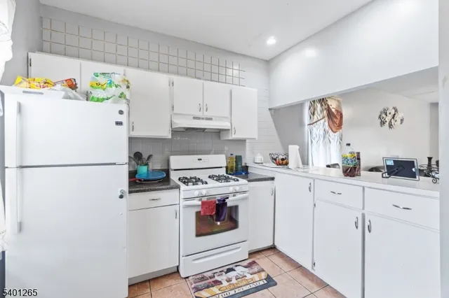 a kitchen with stainless steel appliances white cabinets and a refrigerator