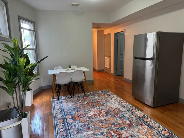a dining room with furniture a rug and wooden floor