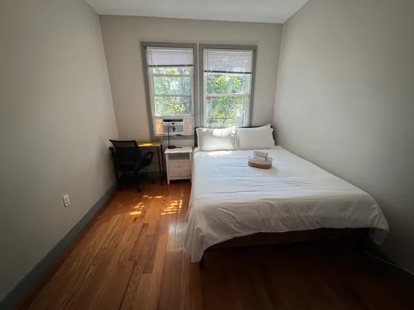 a bedroom with a bed and wooden floor