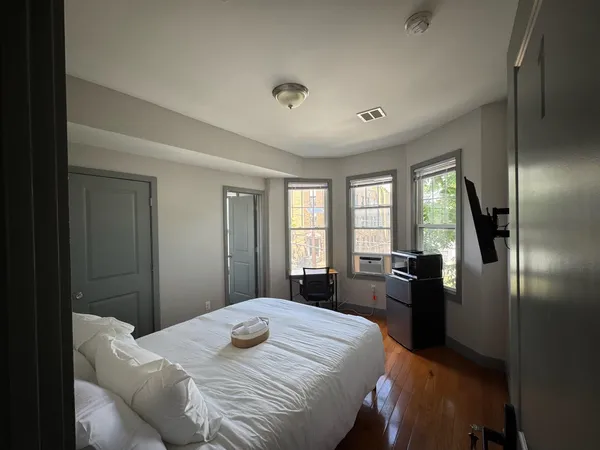 a bedroom with a bed and a large window