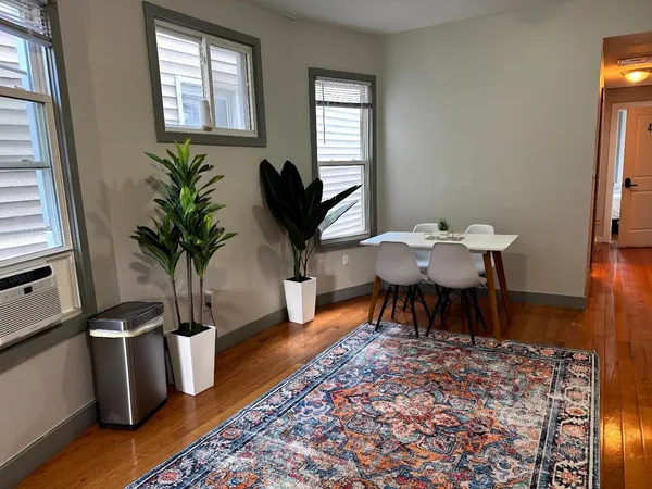 a dining room with furniture a rug and wooden floor