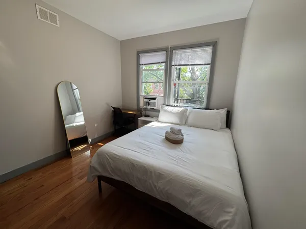a bedroom with a bed and wooden floor
