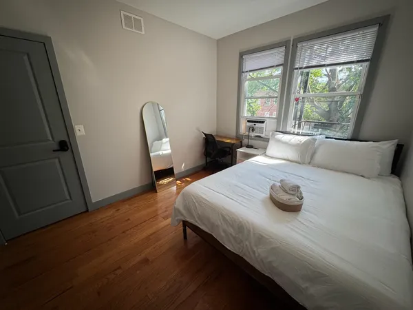 a bedroom with a bed and wooden floor