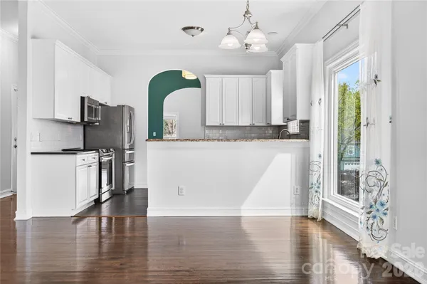 a view of a kitchen with a sink and dishwasher with wooden floor
