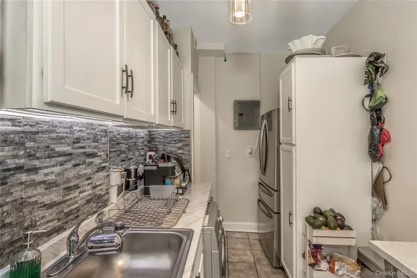 a bathroom with a granite countertop sink a mirror and shower