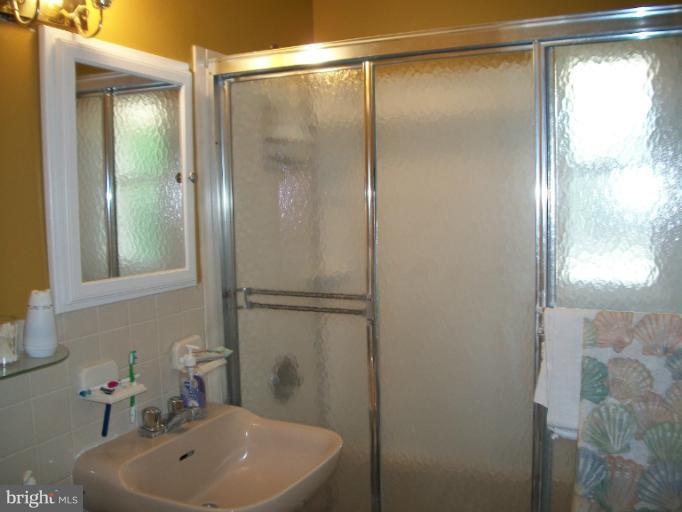7310 Old Keene Mill Road Springfield, VA 22150 - Photo 14 of 30 a bathroom with a sink a mirror and a shower