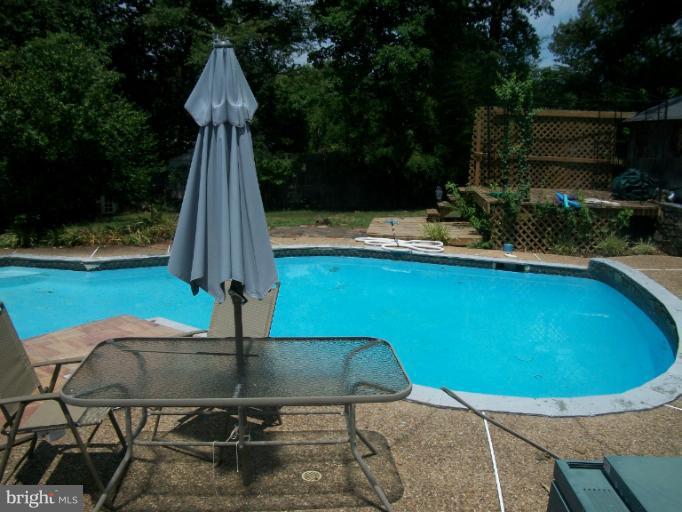 7310 Old Keene Mill Road Springfield, VA 22150 - Photo 15 of 30 a view of a swimming pool with a patio and plants