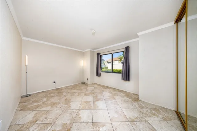 a view of an empty room with window and closet area
