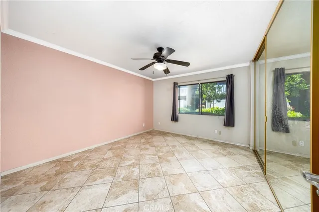 a view of an empty room and window and chandelier fan