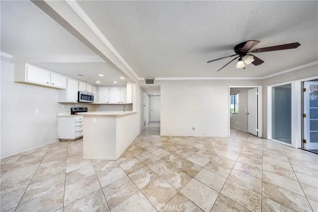a view of a kitchen with sink microwave and cabinets