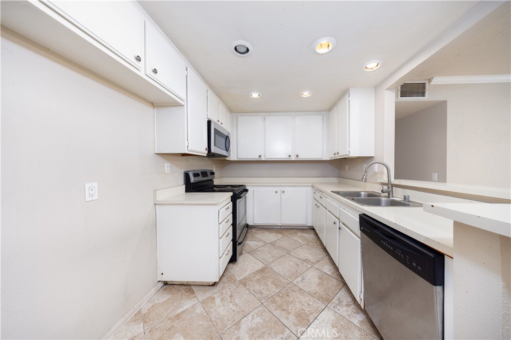 21 Country Mile Road Pomona, CA 91766 - Photo 6 of 18 a kitchen with a sink a stove top oven and white cabinets