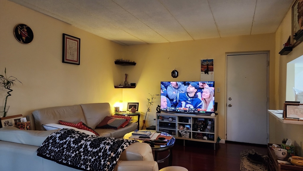 157 Franklin Street, Unit D1 Stoneham, MA 02180 - Photo 3 of 16 a living room with furniture a couch and a flat screen tv