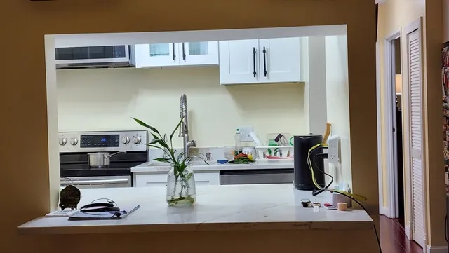 a view of kitchen appliances and cabinets