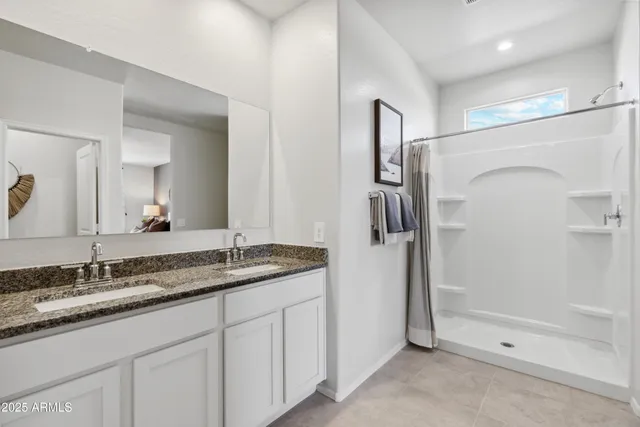 a bathroom with a granite countertop sink mirror and shower