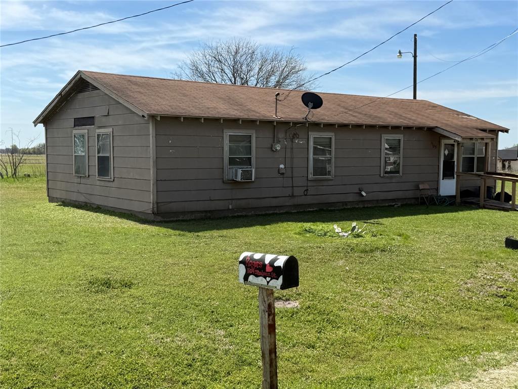 1105 Shabazz Street Milford, TX 76670 - Photo 4 of 6 Back of property featuring a yard and a shingled roof