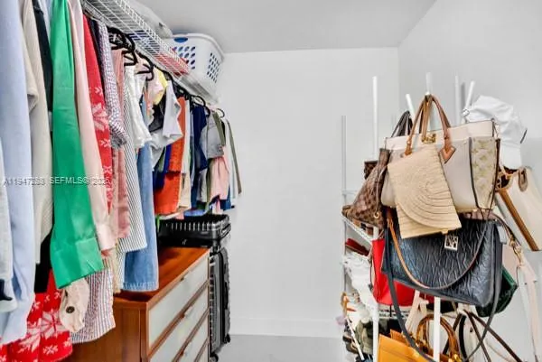 a view of walk in closet with clothes and shoes