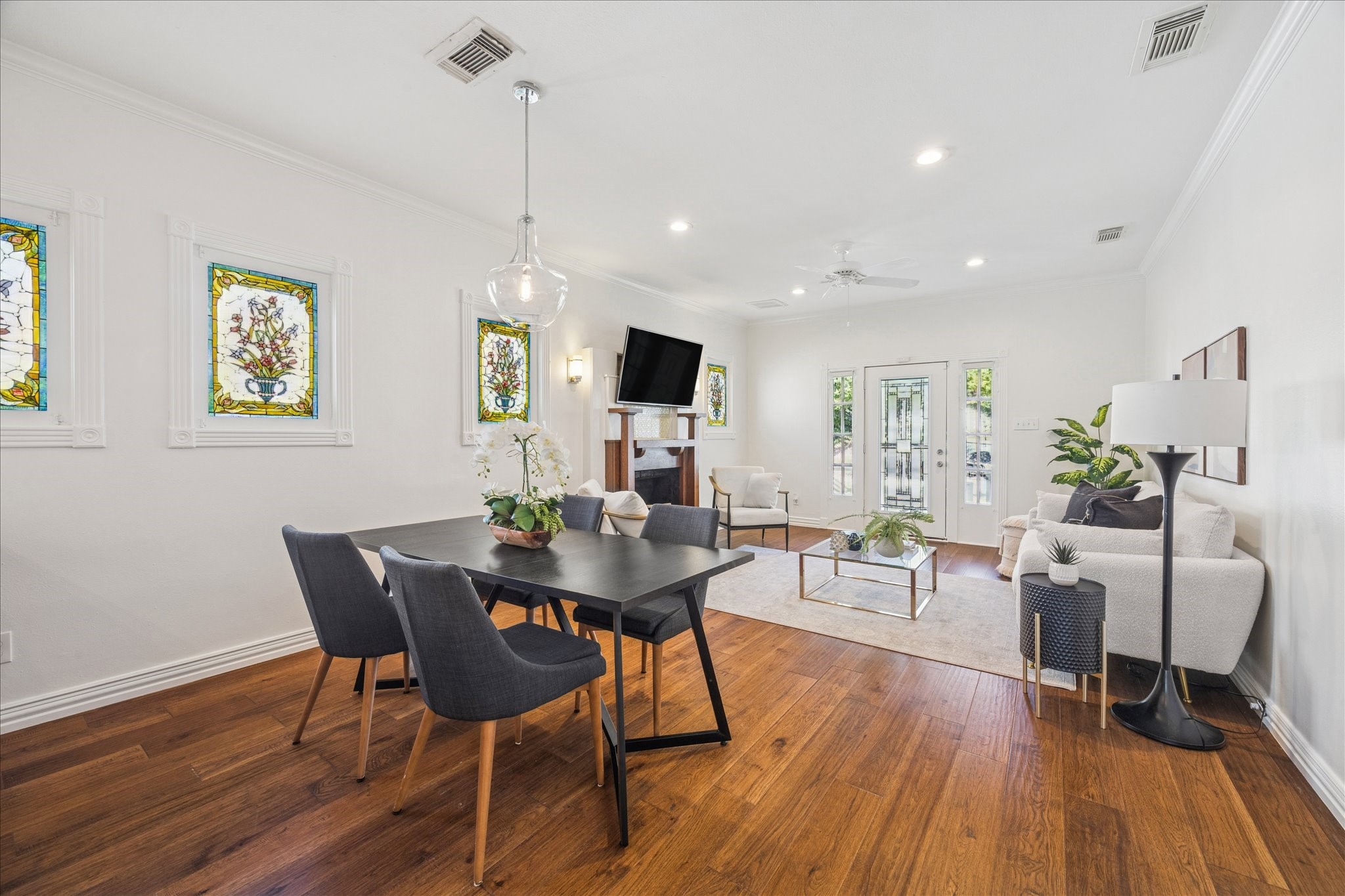 709 Walton Street Houston, TX 77009 - Photo 15 of 31 Combined dining and living space featuring wood flooring and stained-glass windows.