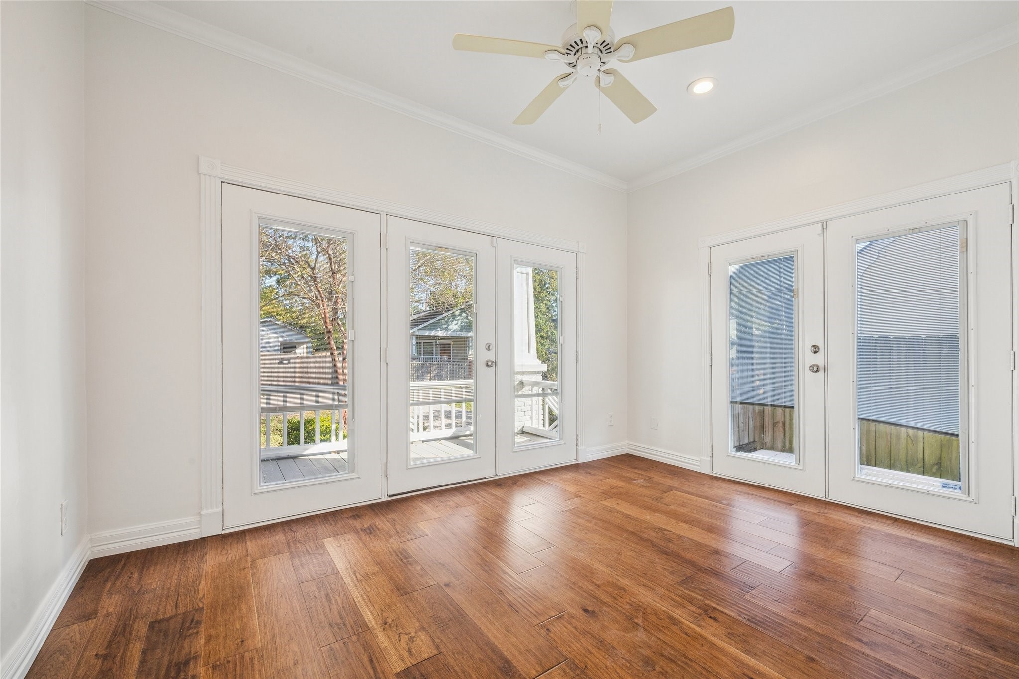 709 Walton Street Houston, TX 77009 - Photo 23 of 31 Bright bedroom #2 featuring wood flooring, recessed lighting, and exterior access through double doors.