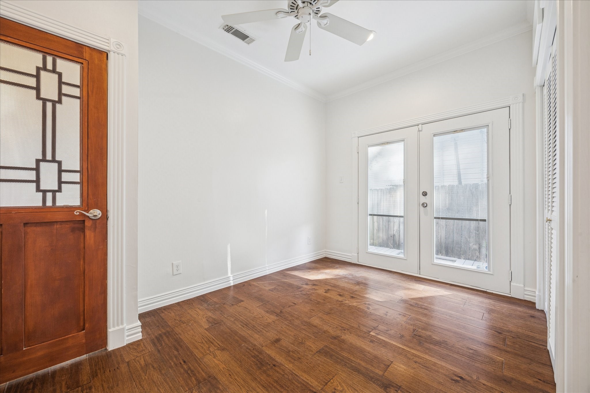 709 Walton Street Houston, TX 77009 - Photo 25 of 31 Bedroom #3 with hardwood floors, ceiling fan, and French doors to the exterior.