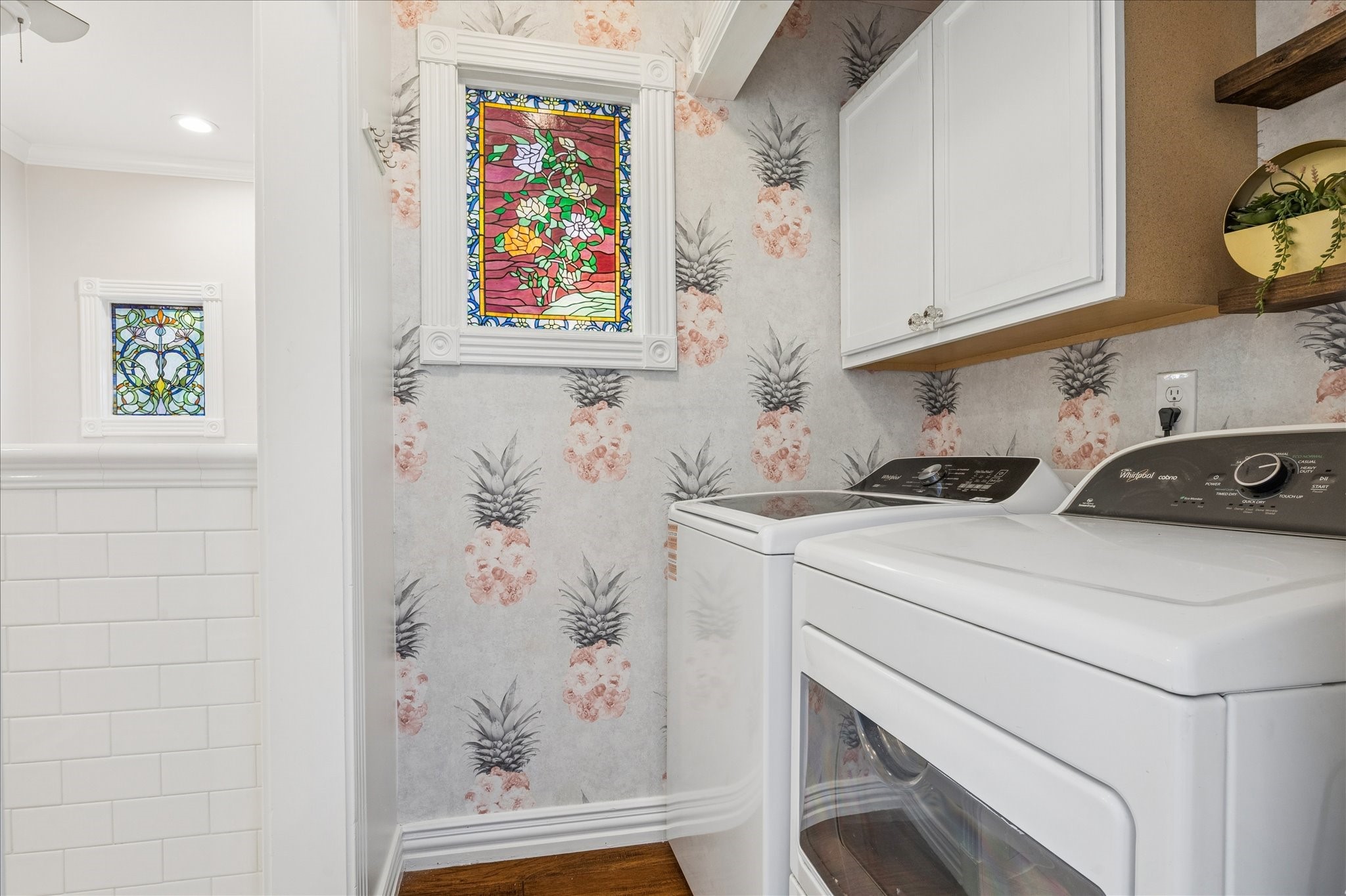 709 Walton Street Houston, TX 77009 - Photo 27 of 31 Laundry area with built-in cabinetry, washer and dryer, and patterned wall detail.