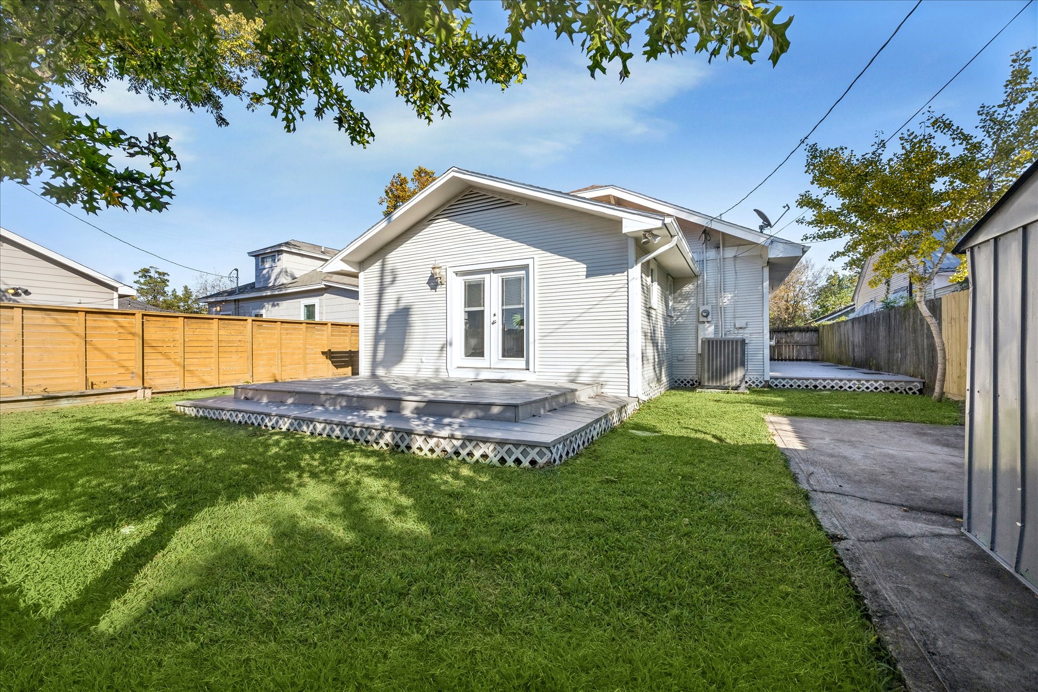 709 Walton Street Houston, TX 77009 - Photo 30 of 31 Rear exterior with deck, fenced yard, and driveway access.