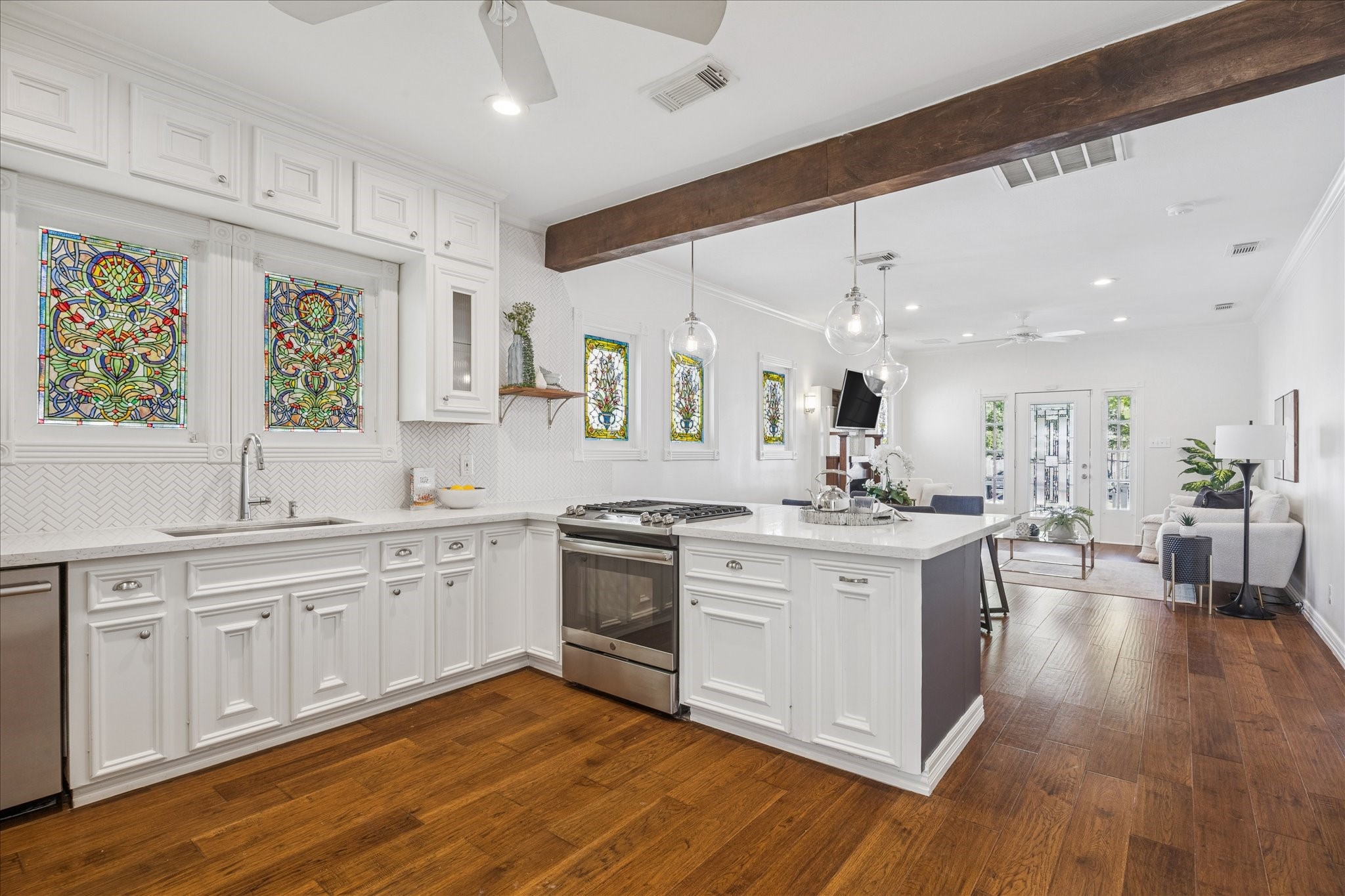 709 Walton Street Houston, TX 77009 - Photo 3 of 31 Bright kitchen featuring quartz counters, gas range, ample storage, and clear sightlines to the main living space.
