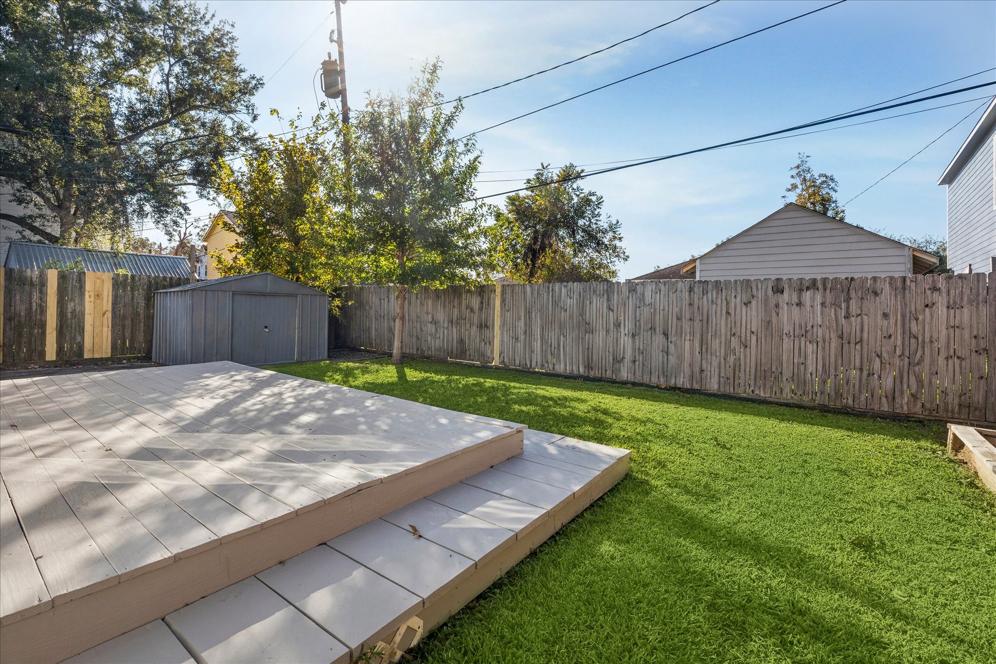 709 Walton Street Houston, TX 77009 - Photo 6 of 31 Backyard features a multi-level deck, mature trees, and a fully fenced perimeter.