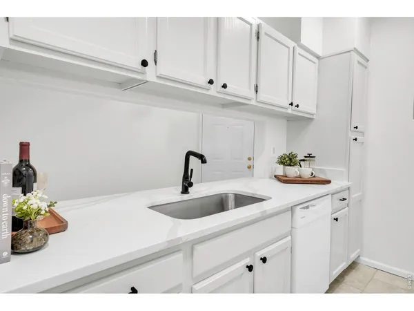 a kitchen with white cabinets and a sink