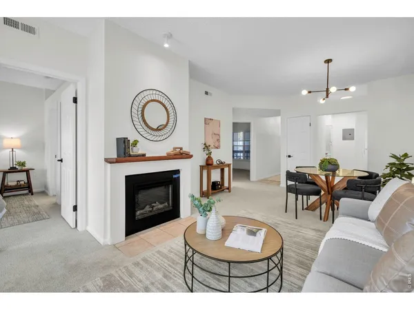 a living room with furniture a fireplace and a potted plant