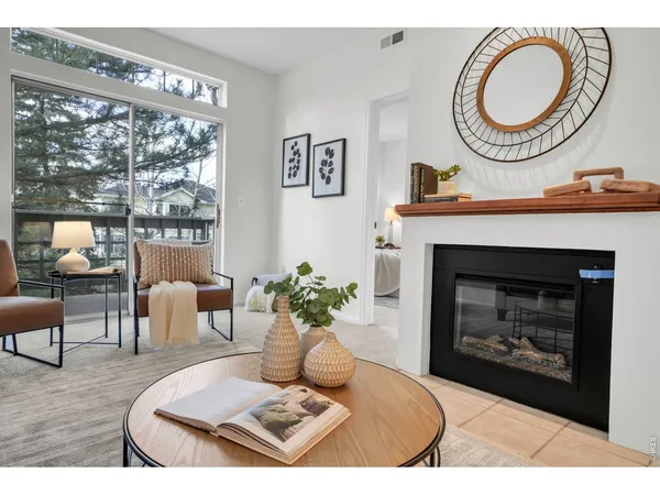 a living room with furniture a fireplace and a large window
